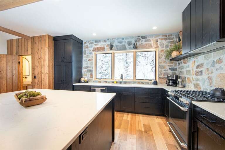 The modern rustic kitchen features high-end appliances & an oversized island with seating for four | Middle Level