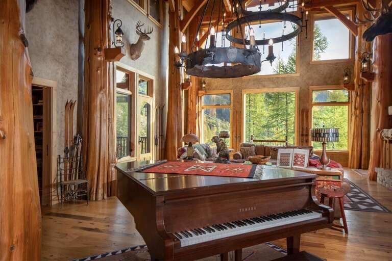 The great room features grand piano, gas fireplace & breathtaking views of Whitefish Mountain Resort | Main Level