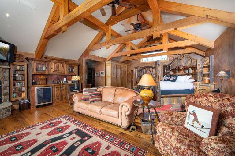 The master suite features a cozy sitting area, a gas fireplace, a kitchenette, and a private balcony with incredible views | Upper Level