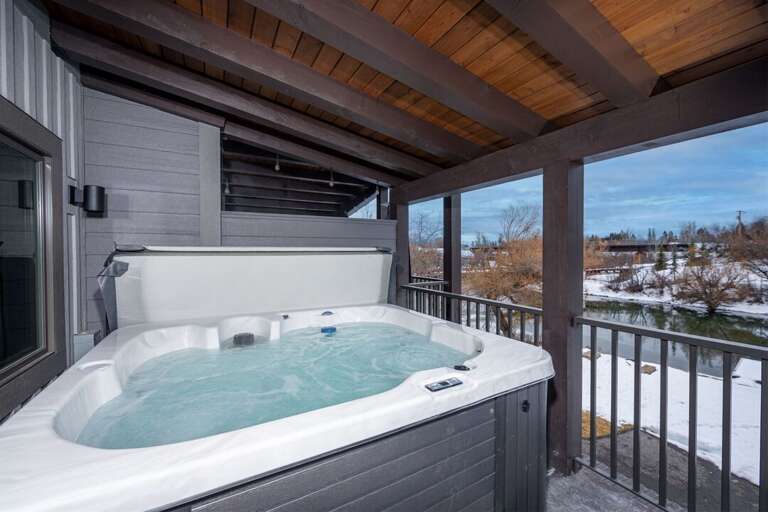 The 3rd floor patio offers seating, a private hot tub, and river views | Exterior