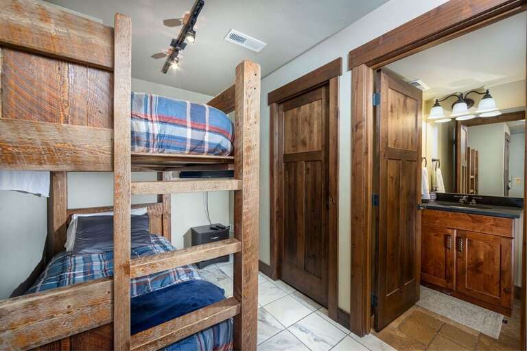 The Floor 1 common area offers twin bunks with a television and half bath | Lower Level
