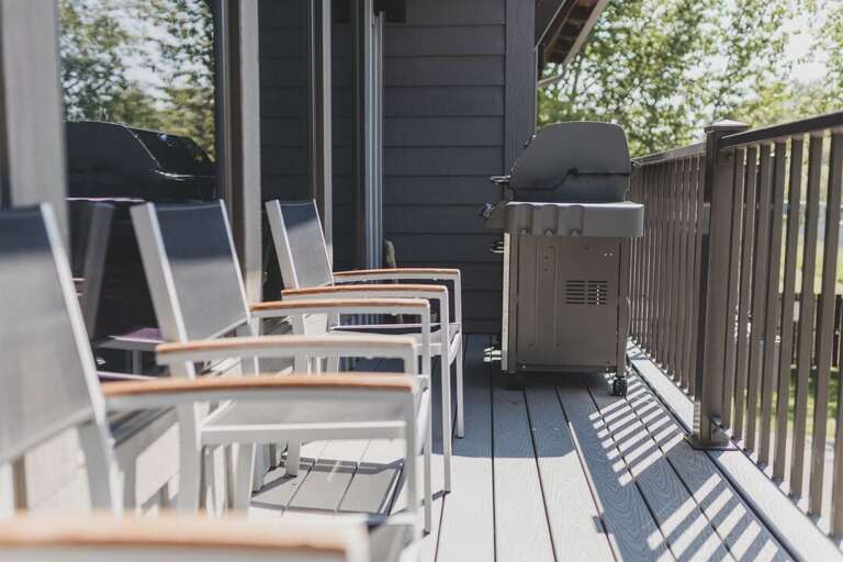 The main floor patio overlooks the Whitefish River and offers a gas grill and seating | Exterior