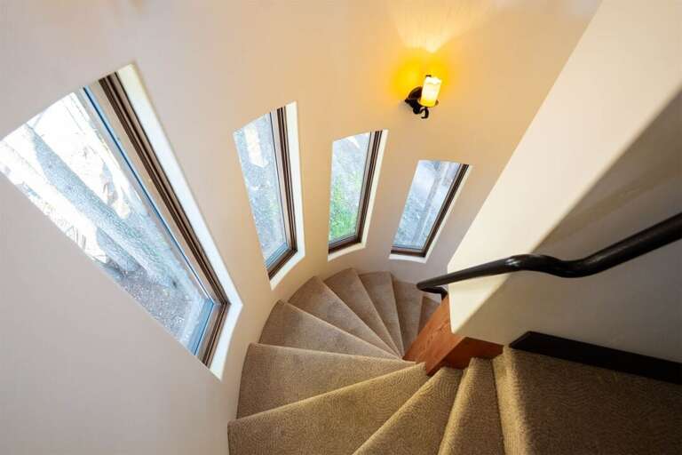 The spiral staircase adds to the creative beauty of the home | Upper Level