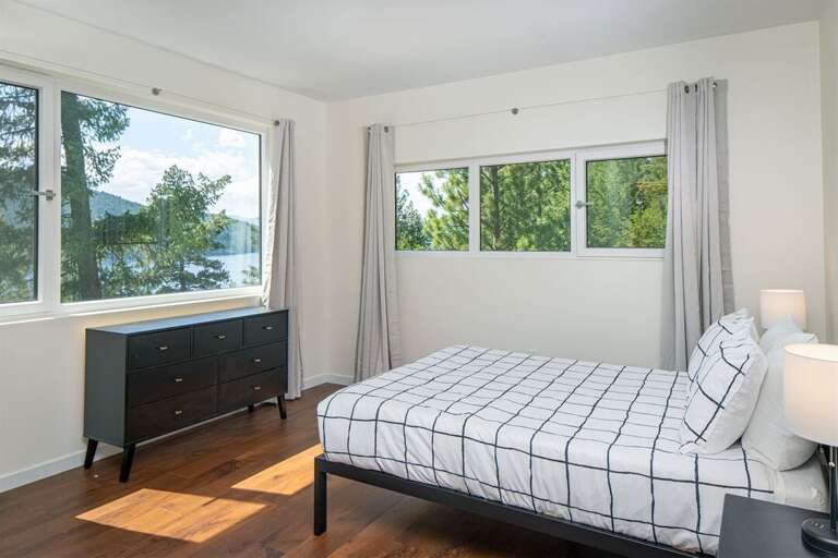 This bedroom offers a queen sized bed, adjoining ensuite & incredible lake views | Upper Level