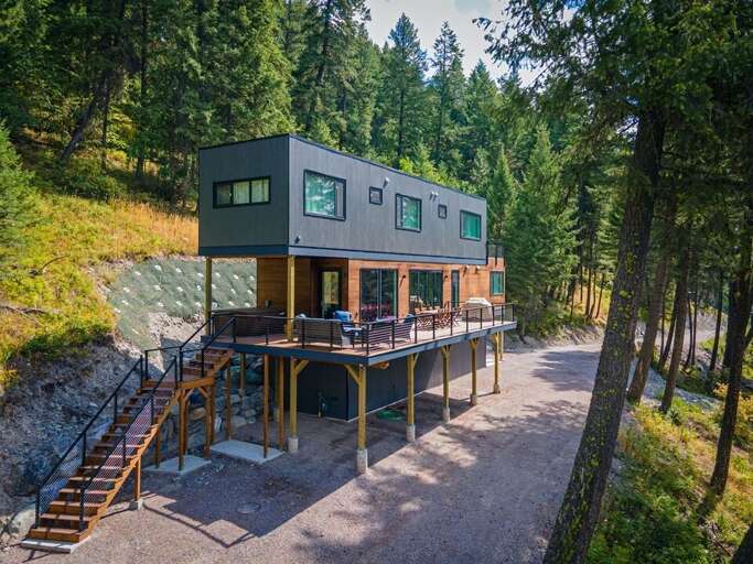 The homes expansive deck offers a dining area, cozy seating & private hot tub | Exterior