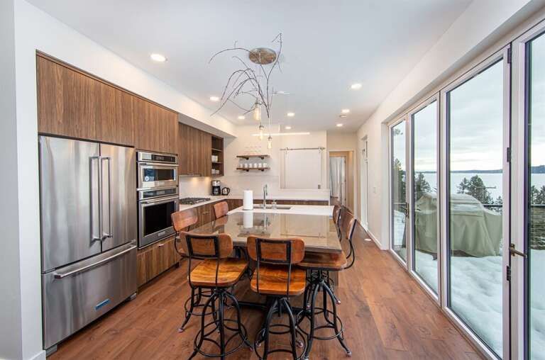 The kitchen and dining area is framed by accordion style doors, providing for incredible lake views | Main Floor