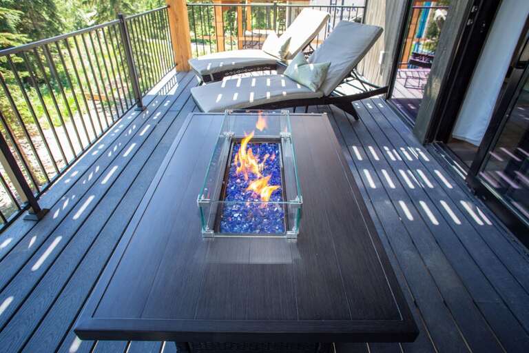 Middle deck, off the master bedroom with 2 lounge chairs, fire pit, and vintage ski chair!