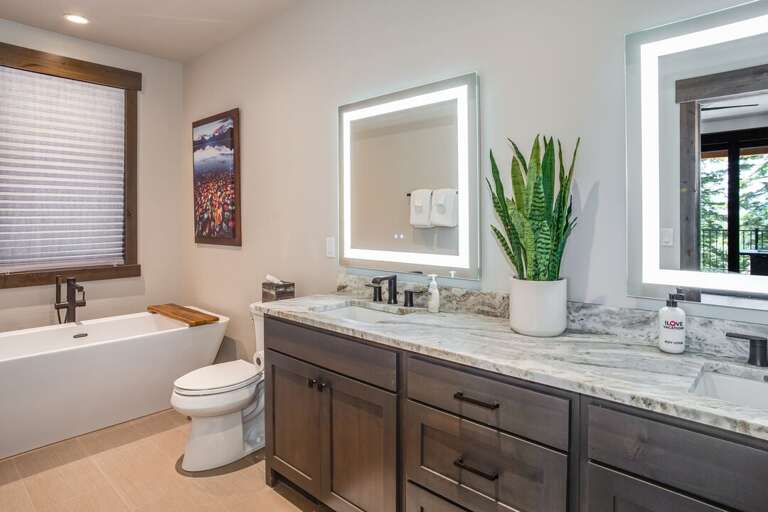 Primary bedroom bathroom with dual vanities, soaking tub, and big 3-valve shower | Middle Level