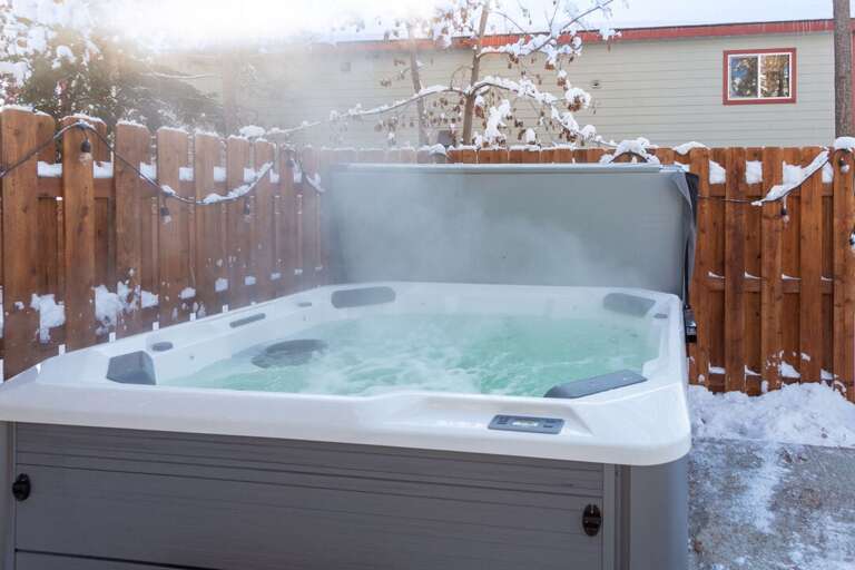 Steam Swirls Over Snow-dusted Spa In Serene Setting