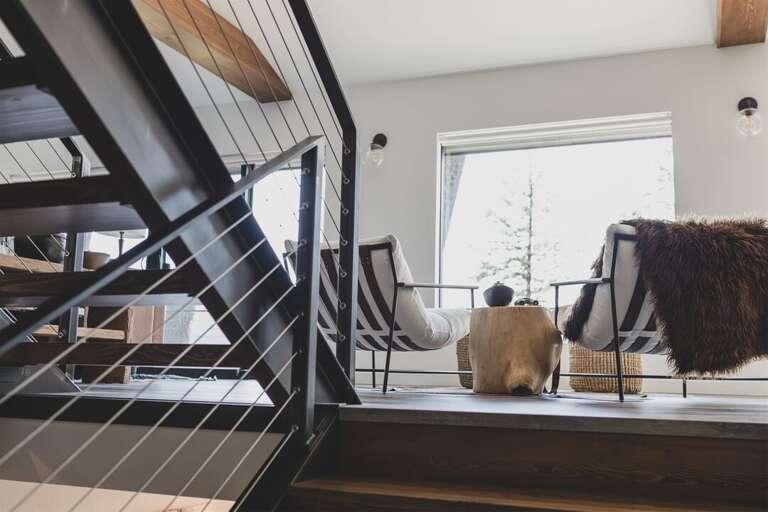 The homes stairwell provides an artful transition between the floors | Main Level