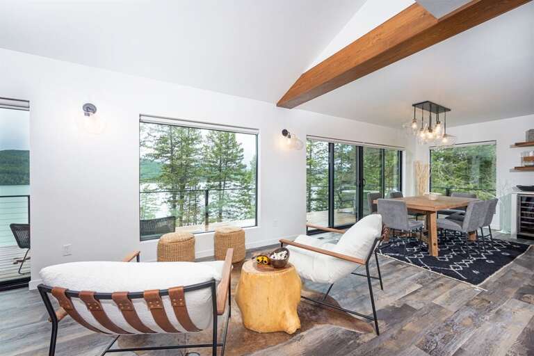 The main living space is framed by windows offering panoramic views of Whitefish Lake | Main Level