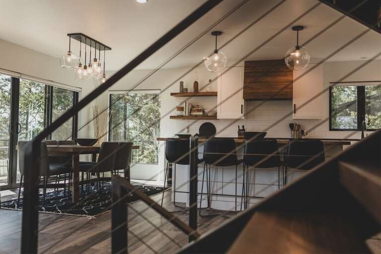 The metal and wood staircase is a beautiful centerpiece in the living area | Main Level