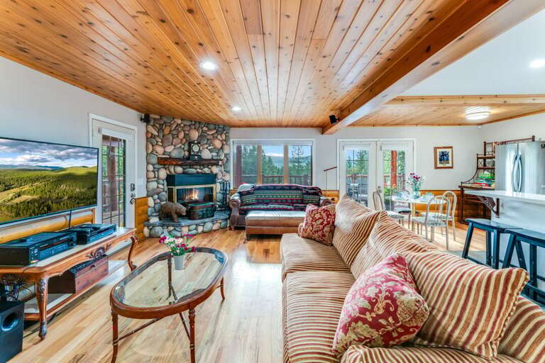 Great Room with Wood Floors and Ceiling and Wood Burning Fireplace | Main Level Great Room with Wood Floors and Ceiling and Wood Burning Fireplace | Main Level