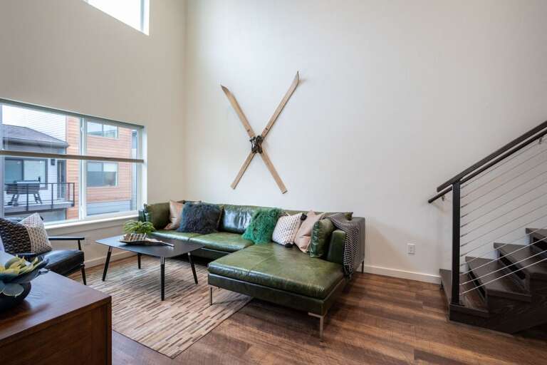 The fun, eclectic, green, leather couch is perfect for relaxing after a long day of exploring | Main Level