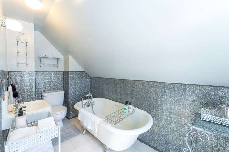 Private bathroom with sink and bear claw tub | Upper Level