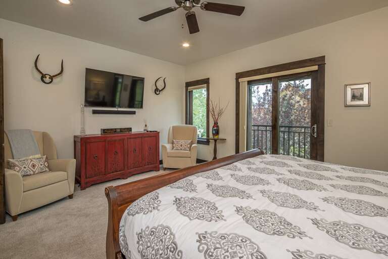 Primary Bedroom with King-sized bed, TV, and balcony | Upper Level