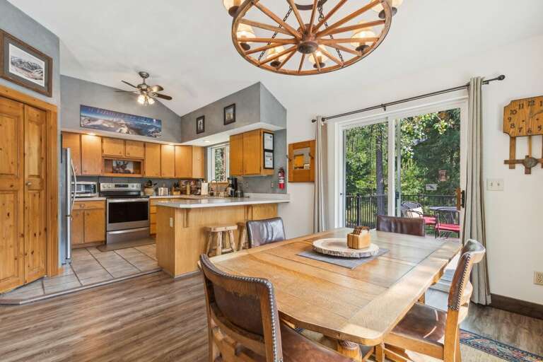 Cozy rustic kitchen and dining area with a peaceful forest view. | Upper Level