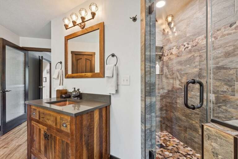 Single vanity sink and newly tiled walk-in shower. | Upper Level