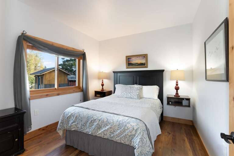 Second bedroom with a queen-size bed and nightstands. | Main Level