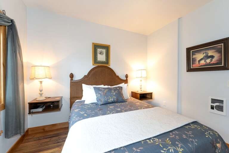 Queen-size bed with rustic decor that creates a cozy retreat. | Main Level