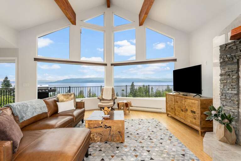 Living room with stunning lake views and wood beams. | Main Level