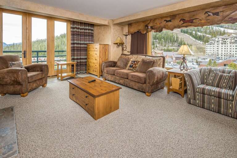 Living Room With Plush Seating And Panoramic Windows Overlooking A Town