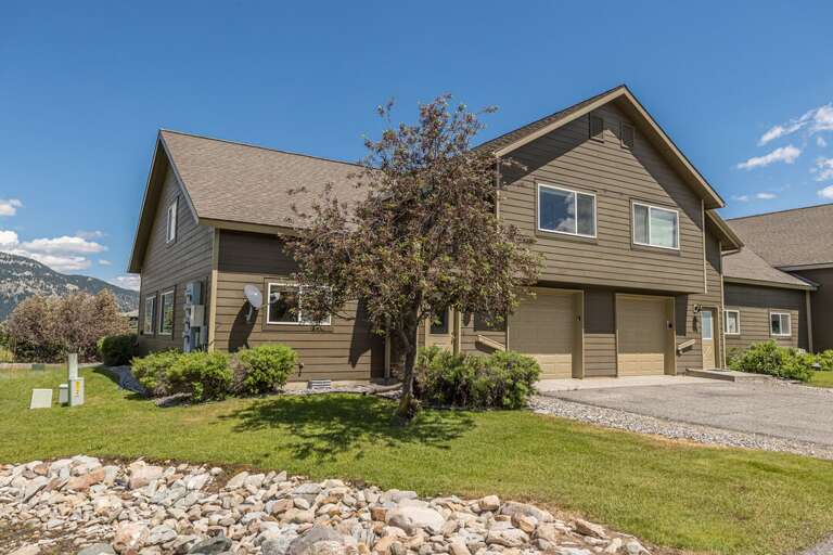 Suburban Structure Shaded By Small Solitary Sapling, Skies Sunny, Surroundings Stony