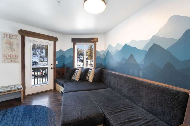 Living room with mountain murals and deck access.