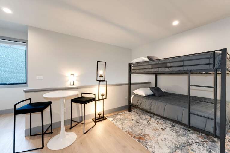 Queen bunk beds with seating area to play cards. | Upper Level