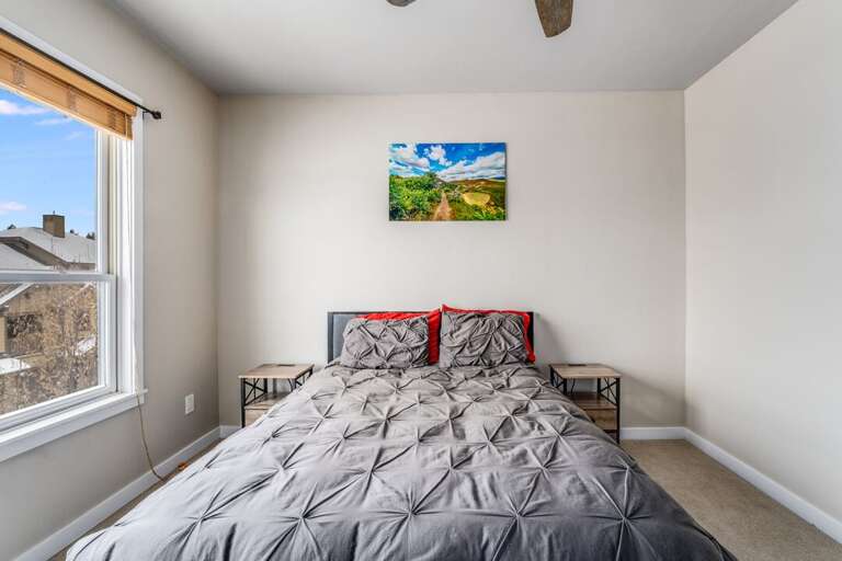 Queen size bed with large window. | Upper Level
