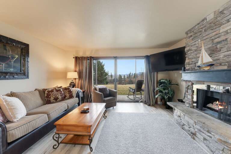 Living room with large tv and fireplace. | Main Level