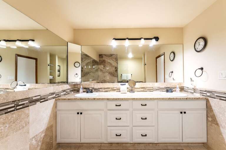 Primary bathroom with dual vanity sinks. | Main Level