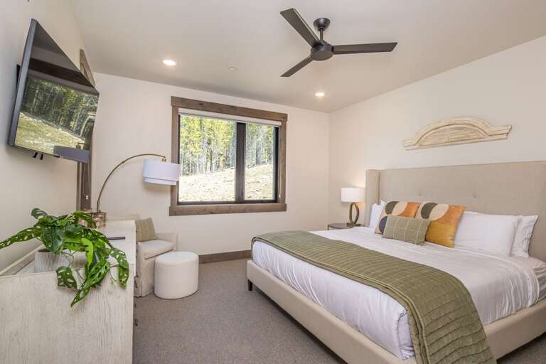 Bright bedroom with large window and bed | Main Level
