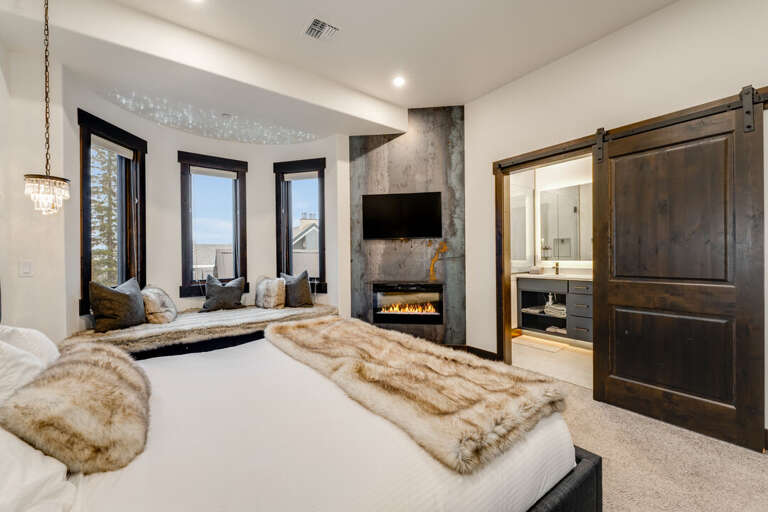 Primary bedroom with fireplace and TV. | Main Level