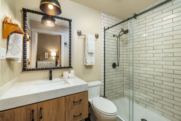 Modern bathroom with tiled shower and stylish vanity I Main Level