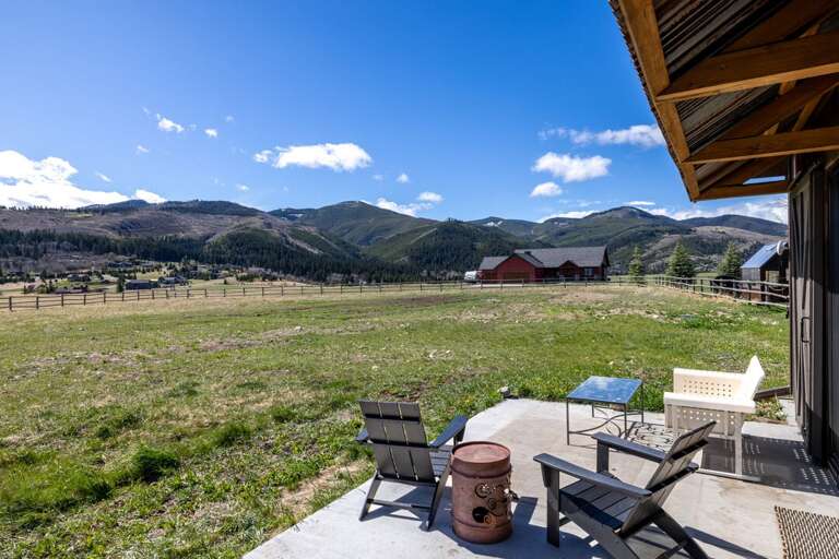 Patio seating with fire pit overlooking land and mountains I Exterior