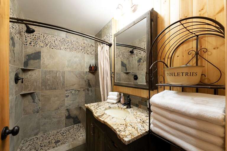 Second bathroom with single vanity and walk in shower. | Main Level