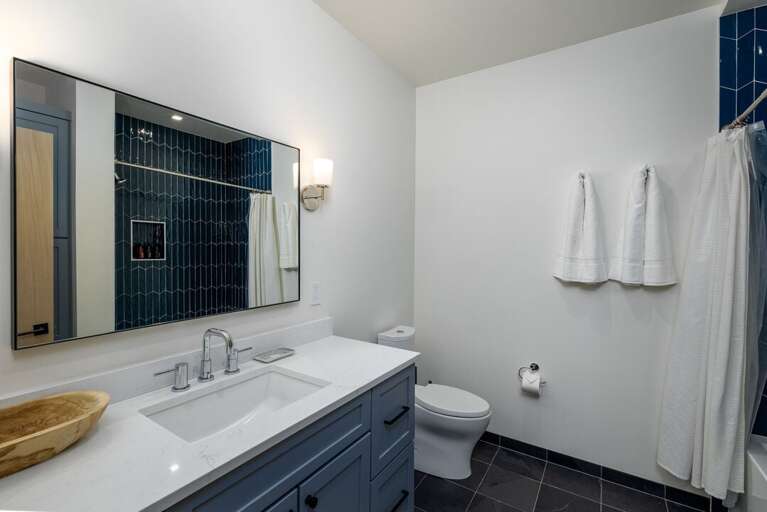 Modern bathroom with sleek blue accents | Upper Level