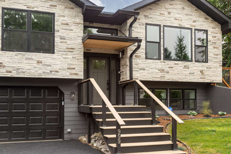 A welcoming entryway framed by big windows and warm wood tones I Exterior