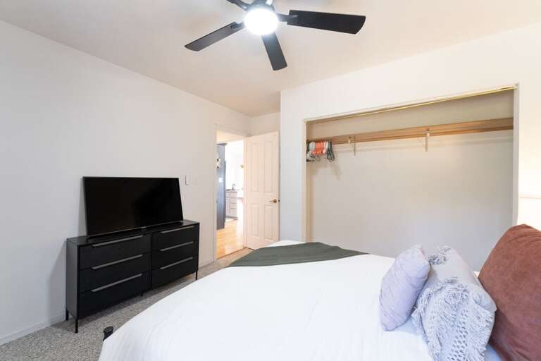 Queen bed, ceiling fan, and TV. | Main Level