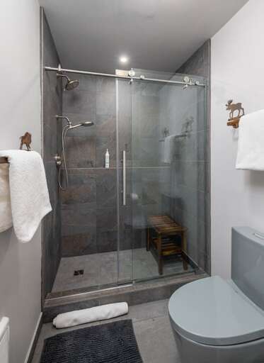Step into the tiled walk-in shower with a built-in bench and glass door.