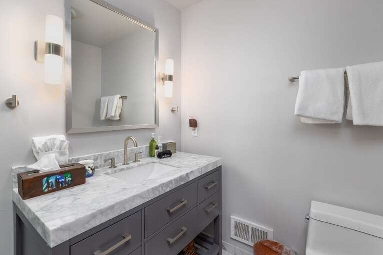 A marble top vanity with plenty of light makes getting ready easy.