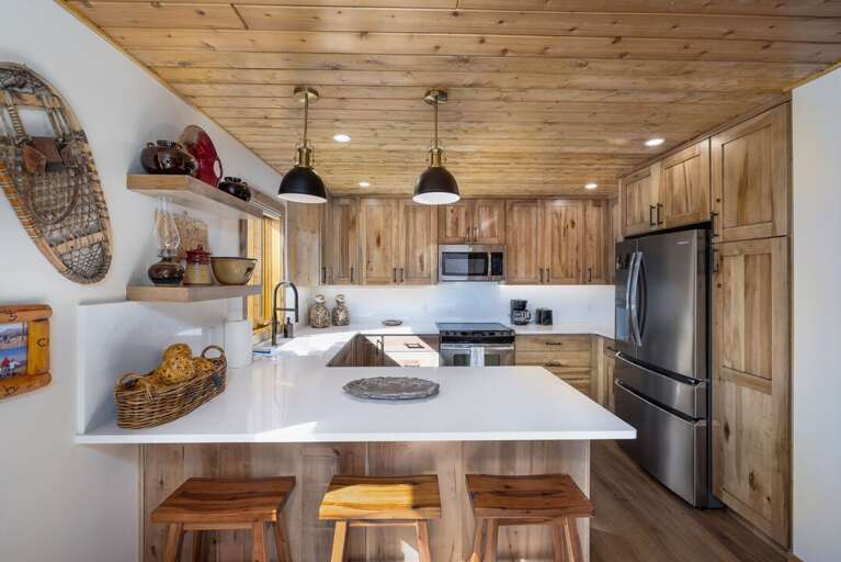 The open kitchen keeps everyone together, with stainless appliances and bar seating at the island.