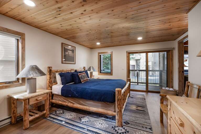 The second king bedroom has a log bed and a glass door out to the deck for fresh mountain air.