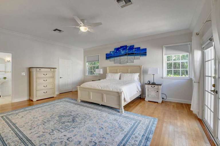 Bright Bedroom With White Walls, Wood Flooring, And Blue Artwork Bright Bedroom With White Walls, Wood Flooring, And Blue Artwork