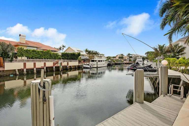 Residential Canal With Docked Boats And Waterfront Homes Residential Canal With Docked Boats And Waterfront Homes