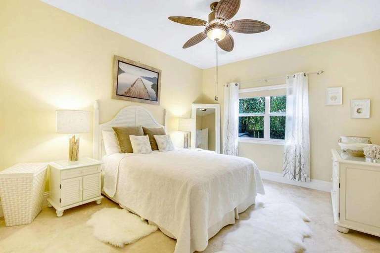 Bright Bedroom With Bed, Ceiling Fan, And Window Bright Bedroom With Bed, Ceiling Fan, And Window