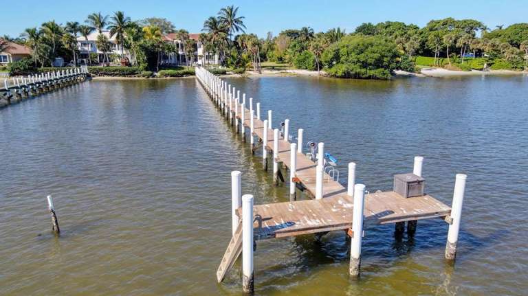 Aerial View Of A Wooden Pier Extending Into A Body Of Water Aerial View Of A Wooden Pier Extending Into A Body Of Water