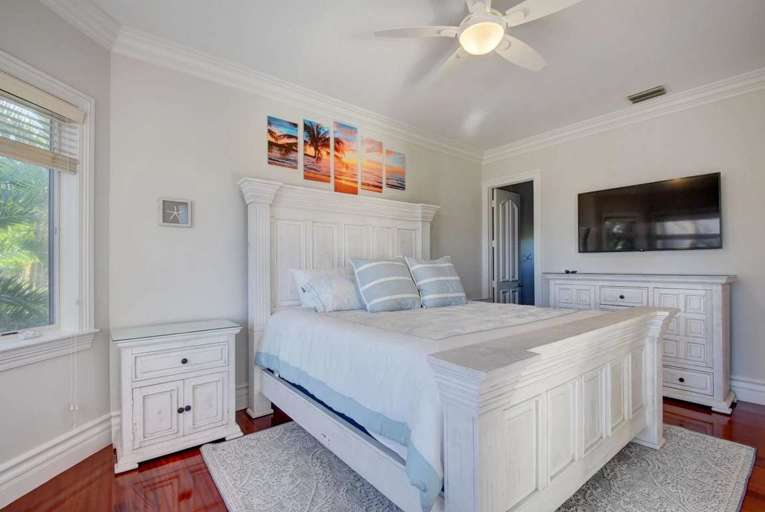 Bright Room With Bed, Ceiling Fan, And TV Bright Room With Bed, Ceiling Fan, And TV