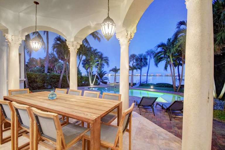 Outdoor Dining Area With Pool View At Dusk Outdoor Dining Area With Pool View At Dusk